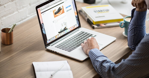 Man looking at website with startup book next to him