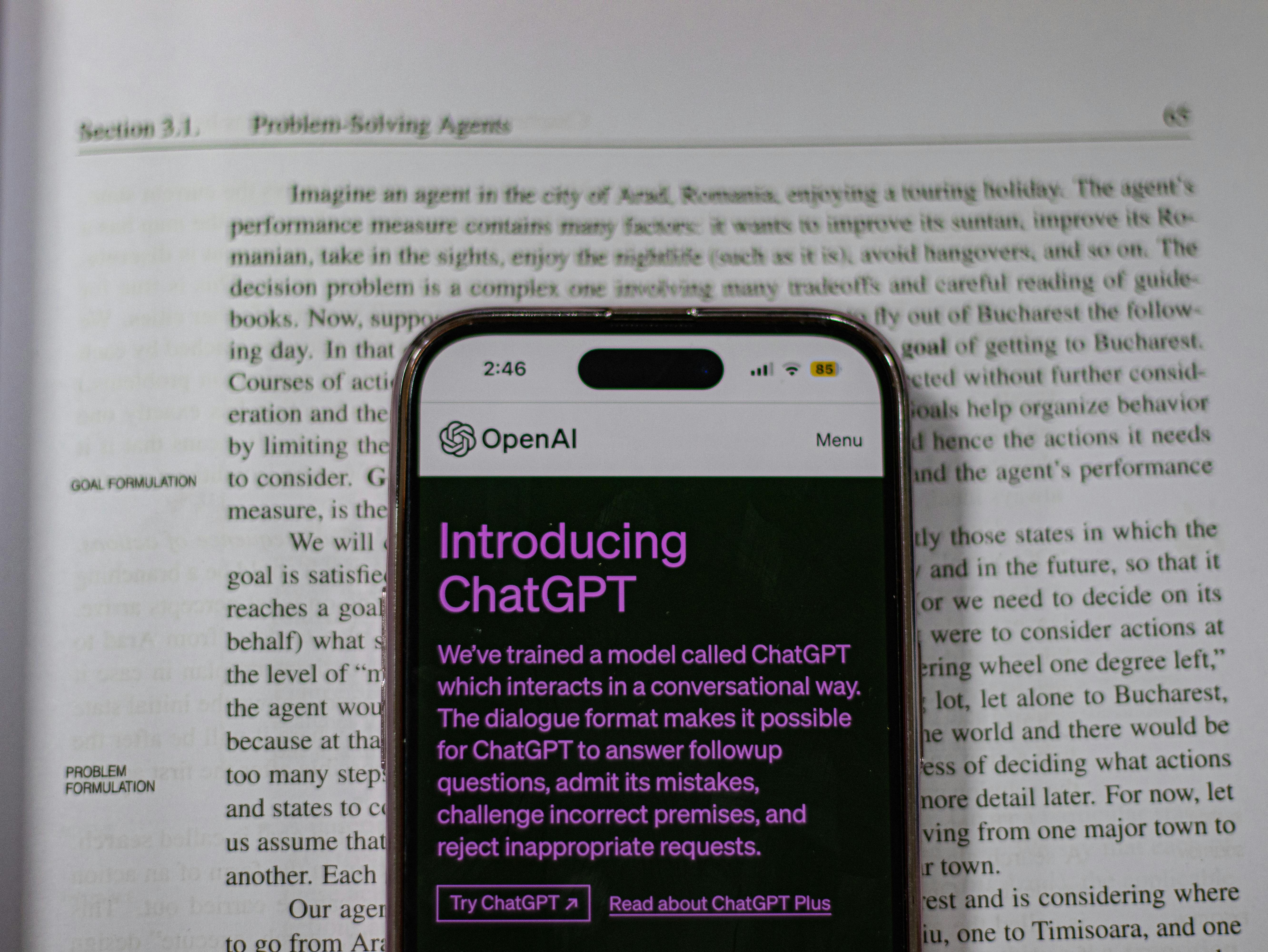 ChatGPT on an Iphone on top of a notebook
